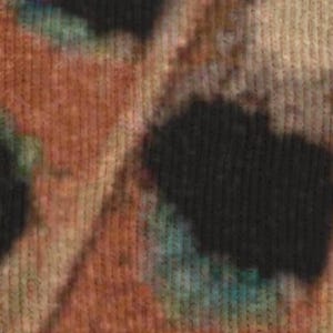 Op de afbeelding: Close-up van een textiel met een tie-dye patroon. De kleuren zijn bruin, zwart en blauwgroen. De stof lijkt gebreid of geweven te zijn, met zichtbare verticale lijnen.