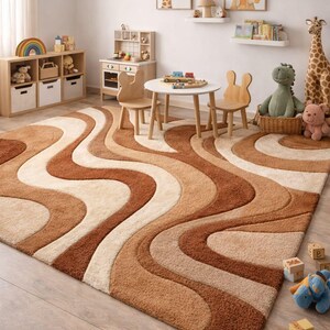 May include: A plush, wavy-patterned area rug in shades of brown, beige, and cream dominates a child's playroom. The rug's design complements the room's wooden furniture, toys, and animal-themed artwork. The room includes a small table and chairs.