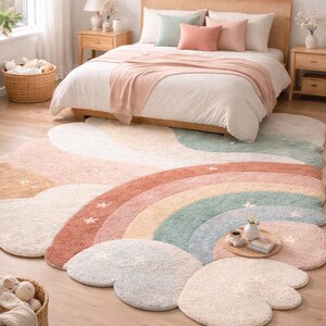 May include: A colorful, cloud-shaped rug with a rainbow design in a bedroom setting. The rug features pastel colors like pink, blue, and beige. The bedroom has a bed with pillows and a wooden frame, and a basket with toys.