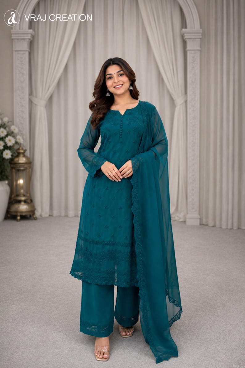 May include: A teal three-piece ensemble featuring a long-sleeved tunic with intricate tonal embroidery, a notched neckline, and a button placket. The set includes wide-leg trousers and a matching sheer dupatta with a scalloped lace border.