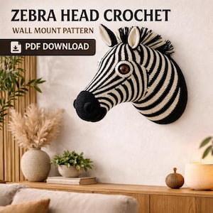 May include: A crocheted zebra head wall mount pattern. The zebra head is black and white with a black nose and brown eyes. The text "ZEBRA HEAD CROCHET" and "WALL MOUNT PATTERN" are at the top of the image. The text "PDF DOWNLOAD" is in a black rectangle.