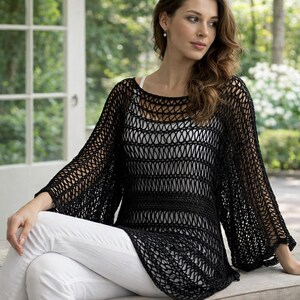 Peut inclure: Un haut en tricot noir à mailles ajourées avec de larges manches. Le haut est porté sur un débardeur blanc et associé à un pantalon blanc. Le motif en tricot crée un effet transparent, offrant un look aéré et élégant. Le haut a une encolure ronde et une coupe décontractée.