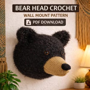 Può includere: Una testa di orso all'uncinetto nera per montaggio a parete. L'orso ha un muso beige e un naso nero. Il testo "BEAR HEAD CROCHET WALL MOUNT PATTERN PDF DOWNLOAD" è nella parte superiore dell'immagine.