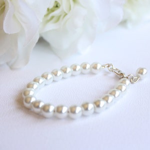 May include: A white pearl bracelet with a silver clasp.