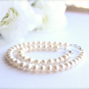 May include: A double strand of white pearl beads with a silver clasp.