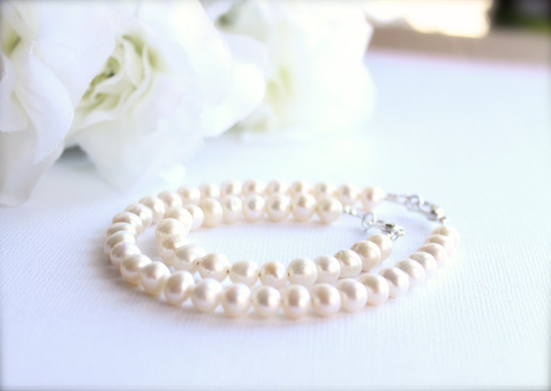 May include: A double strand of white pearl beads with a silver clasp.