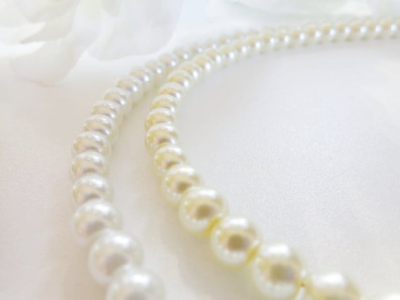 Puede incluir: Un collar de perlas blancas sobre un fondo blanco.