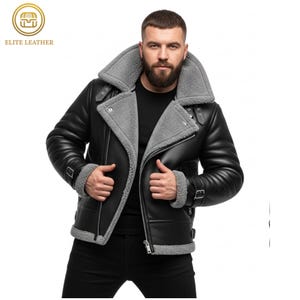 May include: Black leather jacket with a gray shearling collar and lining. The jacket features a zip closure, buckle details, and a classic aviator style. The Elite Leather logo is visible in the upper left corner.