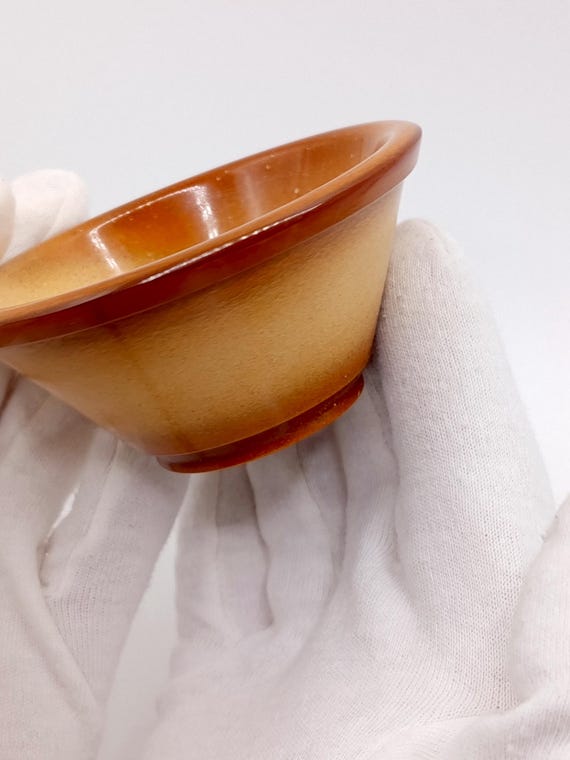 Real pressed amber cast into a glowing translucent dish — feels like holding a piece of prehistoric forest light on your desk.