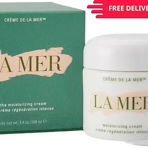 May include: A white jar of La Mer moisturizing cream with a matching box. The box and jar feature the brand name in a gold-colored font. The box is teal green and has the text "Crème de la Mer" at the top.