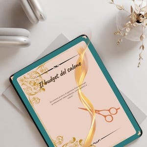 Può includere: Un tablet digitale con il testo "Il budget del salone" e decorazioni dorate. Il tablet ha un bordo verde acqua e uno sfondo color pesca. È visibile anche un paio di forbici arancioni.