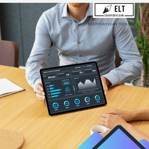 Può includere: Un tablet mostra un dashboard di stato settimanale con dati finanziari e grafici. Lo schermo mostra numeri, grafici e il testo "ELT EVERYDAYLEAN EVERYDAY LEAN TOOLS". Il tablet è tenuto da una persona a un tavolo di legno.