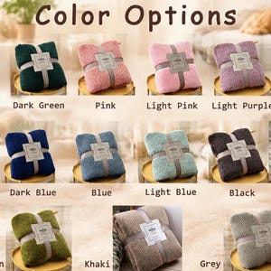 May include: A collection of seventeen folded blankets in various colors including dark coffee, dark green, pink, light pink, light purple, purple, brown, dark blue, blue, light blue, black, white, green, khaki, and grey, each with a paper label.