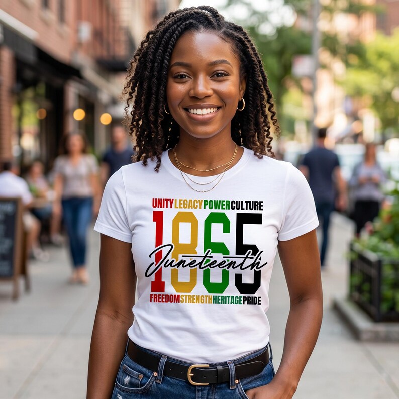 K&ouml;nnte beinhalten: Ein wei&szlig;es T-Shirt mit dem Text "UNITY LEGACY POWER CULTURE" &uuml;ber den Zahlen "1865" in Rot, Gold, Gr&uuml;n und Schwarz. Das Wort "Juneteenth" ist darunter in Kursivschrift geschrieben, mit "FREEDOM STRENGTH HERITAGE PRIDE" darunter.