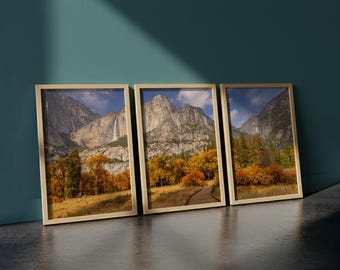 May include: Three framed landscape prints featuring mountain scenes with waterfalls, trees, and a wooden walkway. The frames are a light beige color, and the artwork showcases autumn colors with blue skies.
