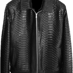 Puede incluir: Una chaqueta negra con un patrón texturizado de piel de serpiente en toda la superficie. La prenda incluye un cuello clásico, un cierre central de cremallera metálica plateada y puños y dobladillo de punto acanalado.