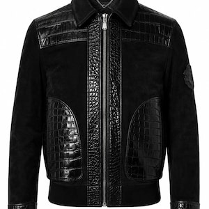 May include: A black jacket featuring a combination of matte suede and glossy, embossed crocodile-patterned leather panels. The garment includes a central silver-tone zip, a classic collar, ribbed cuffs, and a circular emblem on the left sleeve.