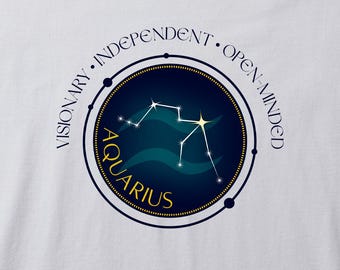 May include: White t-shirt featuring a circular design with the Aquarius constellation in white. The design includes the word "Aquarius" in gold, surrounded by the words "Visionary, Independent, Open-Minded". The background is a dark blue circle with teal waves.