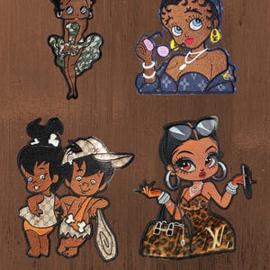 Peut inclure: Quatre écussons brodés représentant des personnages de dessin animé. En haut à gauche : un personnage en robe camouflage. En haut à droite : un personnage avec un couvre-chef bleu et des lunettes. En bas à gauche : deux personnages en tenues à motifs. En bas à droite : un personnage avec une robe et un sac à main à imprimé léopard.