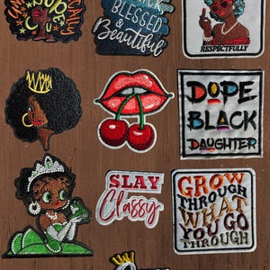 May include: A collection of ten embroidered patches featuring various designs including text such as Unapologetically Dope, Black Blessed & Beautiful, Respectfully, Dope Black Daughter, Slay Classy, Grow Through What You Go Through, and Queen, alongside illustrations of a person with a crown, red lips with cherries, and a cartoon character.