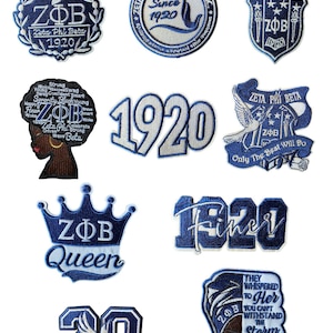 Könnte beinhalten: Eine Sammlung von blau-weißen, gestickten Aufnähern mit den griechischen Buchstaben ZΦB, dem Jahr 1920 und anderen Designs im Zusammenhang mit einer Studentenverbindung. Einige Aufnäher enthalten die Wörter "Queen" und "Finer".