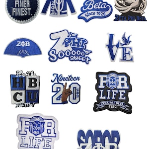 Peut inclure: Un assortiment d'écussons brodés bleus et blancs avec divers motifs et textes. Les écussons incluent des phrases comme "FINE FINER FINEST", "Zeta Phi Beta" et "FOR LIFE". Certains écussons présentent une colombe ou une veste.