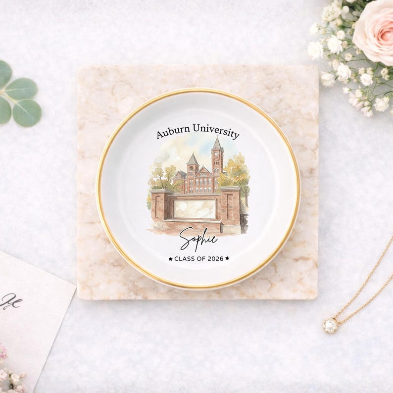 May include: A white ceramic trinket dish with a gold rim, featuring a watercolor illustration of Auburn University. The dish is personalized with the name "Sophie" and "CLASS OF 2026".