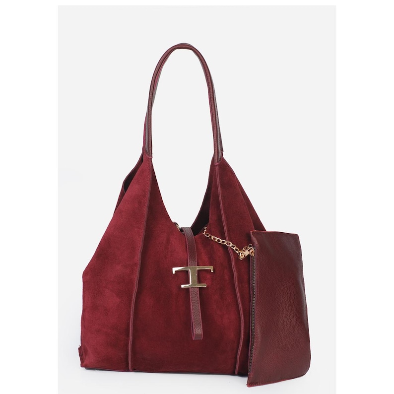 May include: A burgundy suede tote bag with a matching detachable pouch. The bag features a gold-tone metal clasp and chain detail. The handles are a darker shade of burgundy.
