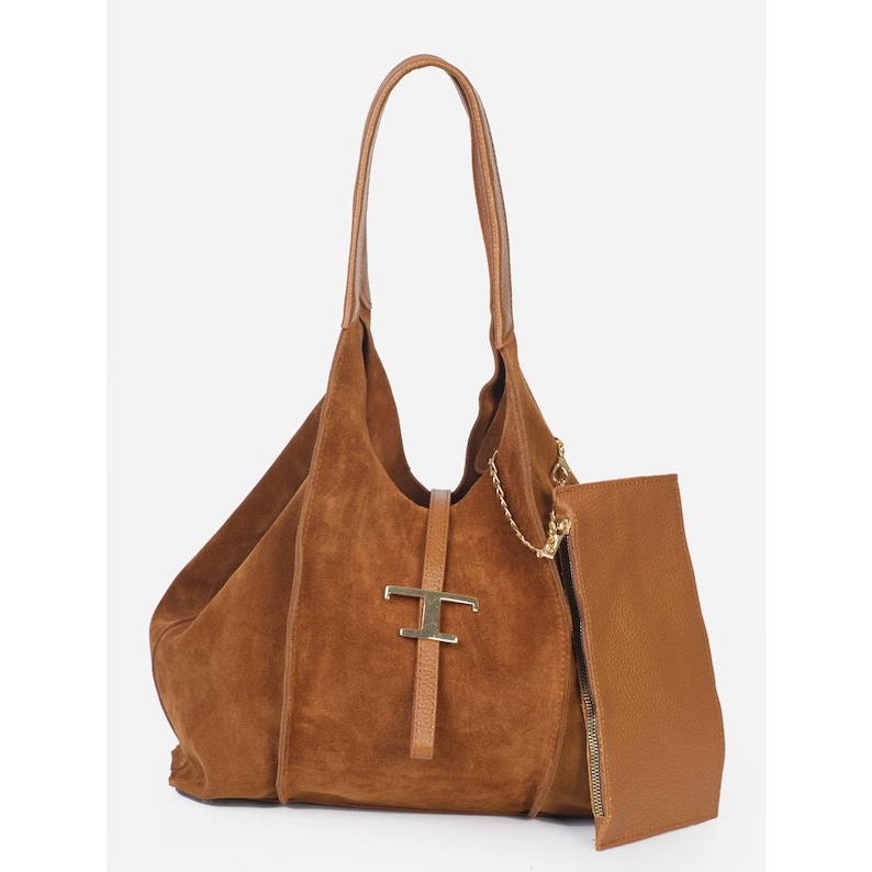 May include: A brown suede shoulder bag with a matching pouch. The bag features a gold-tone metal clasp and a long handle. The pouch has a zipper closure and a gold chain detail. The bag is a rich, warm brown color.