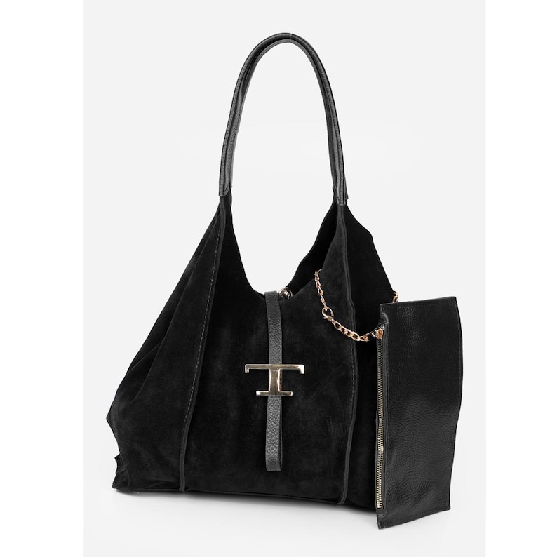 May include: Black suede tote bag with a leather handle and a gold-tone metal clasp. The bag features a detachable pouch with a zipper closure and a gold chain detail. A stylish and functional accessory.