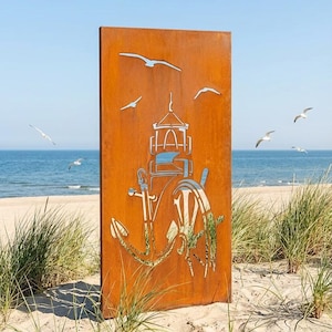 Könnte beinhalten: Ein rechteckiges Metallkunstwerk mit maritimem Thema. Es zeigt einen Leuchtturm, einen Anker und ein Steuerrad als Ausschnitte. Das rostorangefarbene Kunstwerk steht an einem Sandstrand, mit Möwen im Hintergrund.