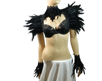 May include: Black feather shoulder and wrist cuffs with black lace trim. The shoulder cuffs are large and dramatic, while the wrist cuffs are more delicate. The cuffs are made of soft feathers and are very comfortable to wear.