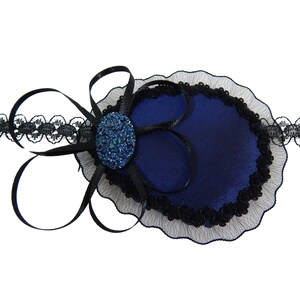 May include: A blue eye patch with black lace trim and a black bow. The eye patch has a blue rhinestone in the center.