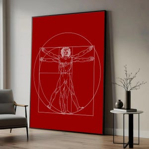 May include: A framed art print featuring Leonardo da Vinci's Vitruvian Man in white against a vibrant red background. The artwork depicts a male figure within a circle and square, showcasing human proportions. The frame is black.