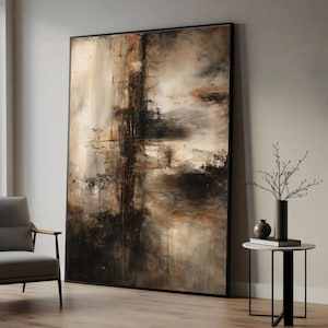 Pode incluir: Grande pintura abstrata emoldurada, em tons de castanho, bege e preto. A obra apresenta pinceladas texturizadas e linhas verticais. É exibida numa sala de estar moderna.