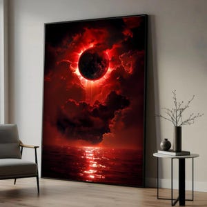 Può includere: Grande stampa artistica incorniciata raffigurante un evento celeste sull'acqua. L'opera presenta un oggetto scuro e circolare circondato da un bagliore rosso brillante, con nuvole rosse e una superficie d'acqua riflettente. Il tema è drammatico e ultraterreno.