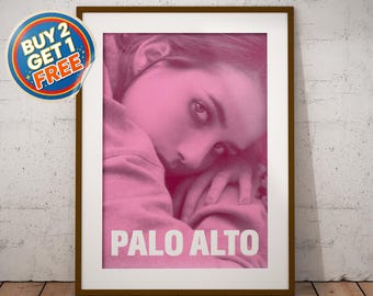 May include: A framed pink-toned print featuring a person in a hoodie, with the word "PALO ALTO" in white block letters. A "BUY 2 GET 1 FREE" sticker is in the upper left corner. The frame is brown.