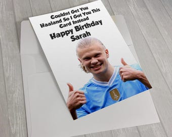May include: A white birthday greeting card featuring a photograph of a soccer player in a light blue jersey giving a double thumbs up. The text reads: Couldnt Get You Haaland So I Got You This Card Instead Happy Birthday Sarah. Includes an envelope.