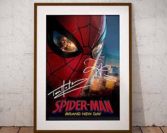 May include: A framed poster featuring a close-up of the red and black Spider-Man mask with a reflection of a person in the eye lens. The poster includes white signatures and the text Spider-Man Brand New Day in red and blue lettering.