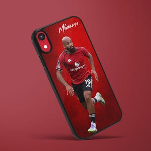 May include: Black phone case featuring a soccer player in a red jersey with the number 19. The player is running on a red background. The name "Mbulemo" is written in white script at the top.