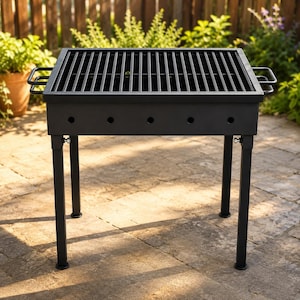 Puede incluir: Una parrilla de carbón negra rectangular con una rejilla metálica, cuatro patas resistentes y dos asas laterales. La caja de fuego incluye una fila de orificios de ventilación circulares a lo largo del panel frontal.