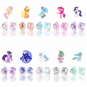 May include: A collection of stud earrings featuring colorful gemstones paired with cartoon pony designs. The earrings showcase various colors, including pink, blue, purple, and green, with a reflective surface. The pony designs are in a circular format.