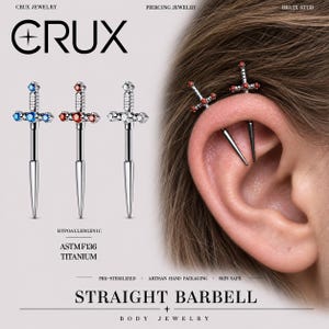 Può includere: Tre piercing a barra dritta a forma di spada in titanio ASTM F136. I gioielli presentano piccole gemme blu, rosse o trasparenti incastonate nell'impugnatura. Il testo CRUX JEWELRY, PIERCING JEWELRY, HELIX STUD e STRAIGHT BARBELL è visibile.