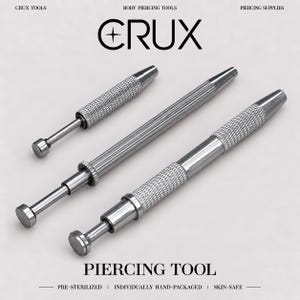 May include: Three silver-toned metal piercing tools with textured, knurled grips and smooth, extendable shafts ending in flat circular tips. The text CRUX, BODY PIERCING TOOLS, PIERCING SUPPLIES, PIERCING TOOL, PRE-STERILIZED, INDIVIDUALLY HAND-PACKAGED, and SKIN-SAFE is visible.