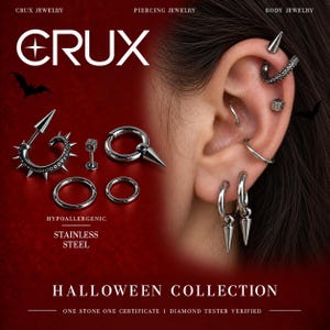 May include: A collection of silver-toned stainless steel body jewelry including an octopus tentacle hoop with spikes, a dice stud, and various plain hoops with spike attachments. The jewelry is displayed alongside an ear wearing similar pieces.