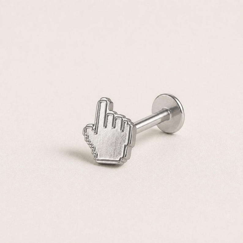 May include: A silver-toned metal body jewelry stud featuring a flat, pixelated computer cursor hand icon at the front. The piece includes a straight post and a circular flat back disc, designed for secure placement in a piercing.