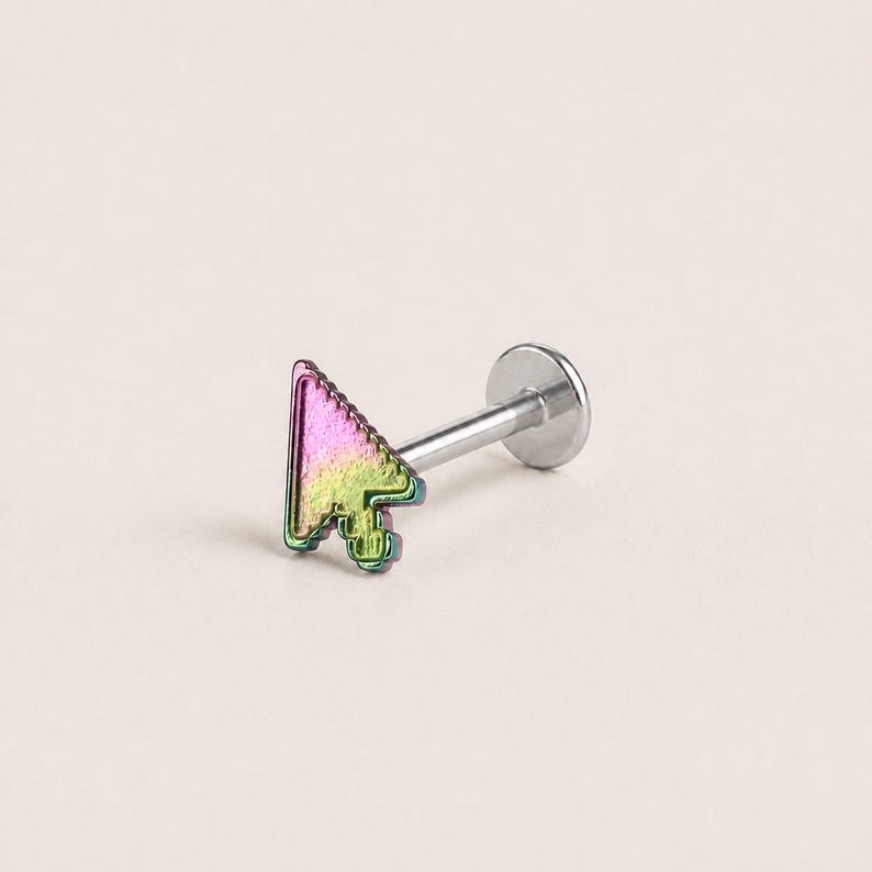 May include: A labret stud body jewelry piece featuring a computer mouse cursor icon. The cursor has an iridescent rainbow finish transitioning from pink to green. It is attached to a straight silver-toned metal post with a flat circular back disc.