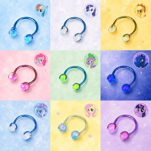May include: A collection of nine horseshoe-shaped body jewelry pieces, each featuring two spherical ends. The metal colors include blue, gold, purple, and iridescent tones, paired with colorful beads in shades of pink, blue, green, and white.