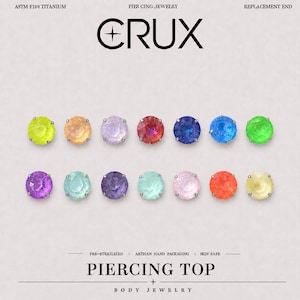 May include: Fourteen round, faceted gemstone piercing tops arranged in two rows. The text reads CRUX, ASTM F136 TITANIUM, PIERCING JEWELRY, REPLACEMENT END, PRE-STERILIZED, ARTISAN HAND PACKAGING, SKIN SAFE, PIERCING TOP, and BODY JEWELRY.