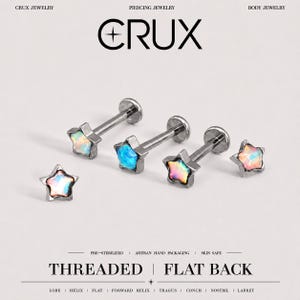 Puede incluir: Cuatro pendientes de piercing en forma de estrella con centros iridiscentes tipo ópalo y postes metálicos. Tres tienen postes de parte posterior plana, mientras que uno es una pieza superior de estrella. Texto: CRUX JEWELRY, PIERCING JEWELRY, BODY JEWELRY, THREADED, FLAT BACK.
